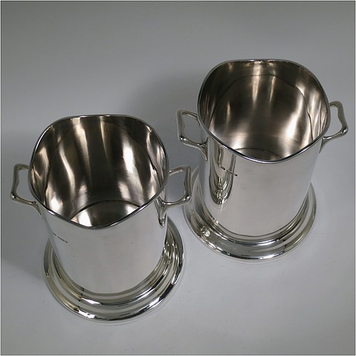 A Sterling Silver pair of syphon stands or champagne / wine bottle holders, having plain round bodies with straight sides, with two cast scroll side-handles, applied wavey-edge reeded borders, and sitting on collet feet. Made by Emile Viner of Sheffield in 1932/33. The dimensions of these fine hand-made silver wine / champagne bottle holders or siphon stands are diameter 12 cms (4.75 inches), height 17 cms (6.75 inches), and they weigh a total of approx. 1,296g (42 troy ounces).