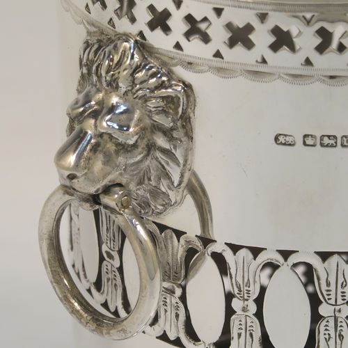 A very pretty Antique Sterling Silver syphon stand, having a round body with straight sides and hand-pierced decoration, with two cast lion-mask ring side-handles, an applied bead-edged top border, and all sitting on a pedestal foot. This elegant silver siphon stand was made by Richard Burbridge of Sheffield for Harrods in 1913. The dimensions of this fine hand-made silver siphon stand are internal diameter 10 cms (4 inches), height 16.5 cms (6.5 inches), and it weighs approx. 450g (14.5 troy ounces).