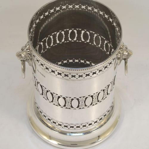 A very pretty Antique Sterling Silver syphon stand, having a round body with straight sides and hand-pierced decoration, with two cast lion-mask ring side-handles, an applied bead-edged top border, and all sitting on a pedestal foot. This elegant silver siphon stand was made by Richard Burbridge of Sheffield for Harrods in 1913. The dimensions of this fine hand-made silver siphon stand are internal diameter 10 cms (4 inches), height 16.5 cms (6.5 inches), and it weighs approx. 450g (14.5 troy ounces).