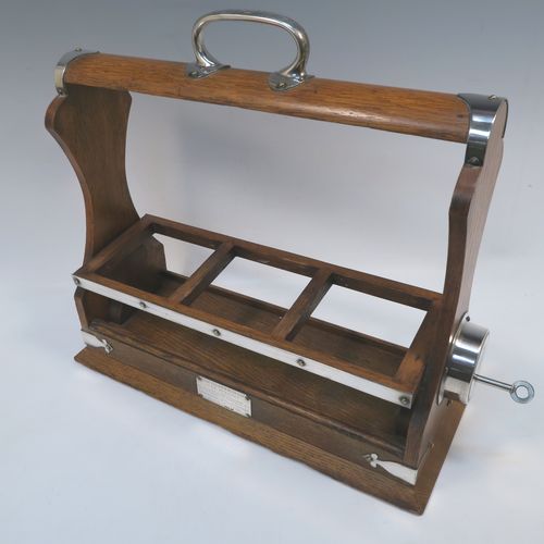 A very handsome Antique Silver-plated and wood framed three-bottle tantalus, with original hand-cut crystal decanters and stoppers, all in an oak (poss.) wooden frame with silver-plated and nickel pinned mounts, with a patented lock mechanism and key. The presentation inscription is engraved onto a sterling silver plaque with hallmarks, which indicate that this beautiful antique silver-plated and wood tantalus was made by Walker and Hall of Birmingham in 1912. The dimensions of this fine hand-made antique three-bottle tantalus are length 36 cms (14 inches), height 32 cms (12.5 inches), and depth 14 cms (5.5 inches).