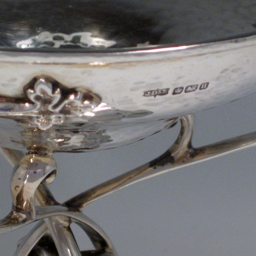Sterling silver Arts & Crafts style hand-hammered tazza dish with three scroll handles, sitting on a pedestal foot above which the handles are inter-twined. Made by James Dixon of Sheffield in 1912. Height 21 cms (8.25 inches), diameter of bowl 16.5 cms (6.5 inches). Weight approx. 20.5 troy ounces (636g).