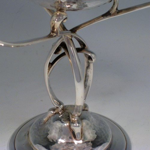 Sterling silver Arts & Crafts style hand-hammered tazza dish with three scroll handles, sitting on a pedestal foot above which the handles are inter-twined. Made by James Dixon of Sheffield in 1912. Height 21 cms (8.25 inches), diameter of bowl 16.5 cms (6.5 inches). Weight approx. 20.5 troy ounces (636g).