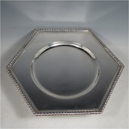 An Antique Sterling Silver very heavy tazza cake dish, having a plain hexagonal body, with a gadroon border, and sitting on a pedestal foot with applied cut-card work and hand-chased fluting. Made by Sebastian Garrard of London in 1911. The dimensions of this fine hand-made antique silver tazza dish are height 8 cms (3 inches), width of plate 31 cms (12.25 inches), and the weight is approx. 1,425g (46 troy ounces).