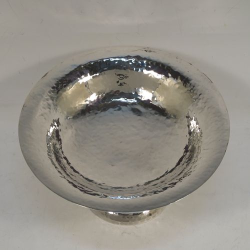 A very handsome Antique Edwardian Sterling Silver Arts and Crafts style tazza dish, having a round bowl attached to a pedestal foot with three scroll arms, and an all-over hand-hammered or plenished finish. This beautiful silver tazza dish was made by Walker and Hall of Sheffield in 1909. The dimensions of this fine hand-made antique silver dish are height 9 cms (3.5 inches), diameter 16 cms (6.3 inches), and it weighs approx. 203g (6.5 troy ounces).   