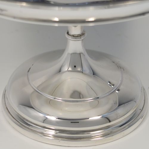 A very handsome Antique Sterling Silver Tazza dish, having a plain round body, with applied reeded borders and two scroll side handles, all raised above and sitting on a plain round pedestal foot. This elegant silver dish was made by Walker and Hall of Sheffield in 1912. The dimensions of this fine hand-made antique silver Tazza dish are height 16.5 cms (6.5 inches), diameter 20 cms (8 inches), and it weighs approx. 464g (15 troy ounces).