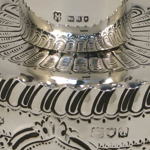 A very pretty Antique Victorian Sterling Silver tea caddy box, having an oval straight-sided body with hand-chased floral, scroll, and swirl-fluted decoration, with a vacant cartouche on both sides and with hand-crimped borders, a pull-off lid with matching decoration, and all sitting on a flat base. This beautiful antique silver tea caddy box was made by Jackson and Fullerton of London in 1899. The dimensions of this fine hand-made antique silver tea caddy box are height 9 cms (3.5 inches), length 8 cms (3.25 inches), width 6.5 cms (2.5 inches), and it weighs approx. 113g (3.6 troy ounces).
