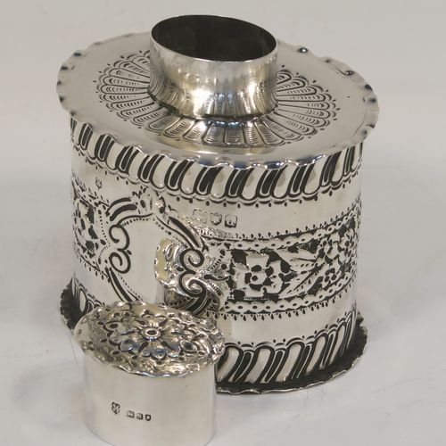 A very pretty Antique Victorian Sterling Silver tea caddy box, having an oval straight-sided body with hand-chased floral, scroll, and swirl-fluted decoration, with a vacant cartouche on both sides and with hand-crimped borders, a pull-off lid with matching decoration, and all sitting on a flat base. This beautiful antique silver tea caddy box was made by Jackson and Fullerton of London in 1899. The dimensions of this fine hand-made antique silver tea caddy box are height 9 cms (3.5 inches), length 8 cms (3.25 inches), width 6.5 cms (2.5 inches), and it weighs approx. 113g (3.6 troy ounces).