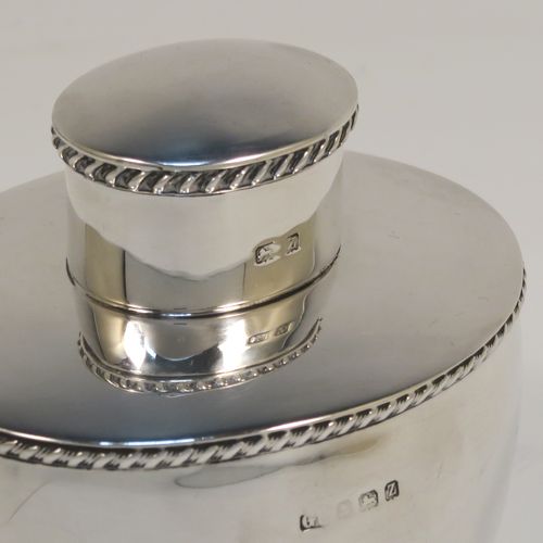 A very handsome Antique Sterling Silver tea caddy box, having an plain oval bellied body with applied gadroon borders, and a pull-off lid which was used as a measure, and all sitting on a flat base. This elegant silver tea caddy box was made by George Unite of Birmingham in 1924. The dimensions of this fine hand-made antique silver tea caddy box are height 8 cms (3.25 inches), length 8 cms (3.25 inches), width 6.5 cms (2.5 inches), and it weighs approx. 118g (3.8 troy ounces).   