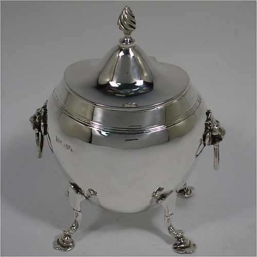 An Antique Edwardian Sterling Silver tea caddy box, having a plain oval bellied body with an upper band of hand-chased reeded decoration, a hinged lid with a cast swirl finial, with two cast lions-head ring side-handles, a gold-gilt interior, and sitting on four cast hoof feet with trefoil shoulders. Made by Nathan and Hayes of Chester in 1906. The dimensions of this fine hand-made antique silver tea caddy box are height 11.5 cms (4.5 inches), width 9 cms (3.5 inches), depth 6.5 cms (2.5 inches), and it weighs approx. 167g (5.4 troy ounces).