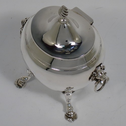 An Antique Edwardian Sterling Silver tea caddy box, having a plain oval bellied body with an upper band of hand-chased reeded decoration, a hinged lid with a cast swirl finial, with two cast lions-head ring side-handles, a gold-gilt interior, and sitting on four cast hoof feet with trefoil shoulders. Made by Nathan and Hayes of Chester in 1906. The dimensions of this fine hand-made antique silver tea caddy box are height 11.5 cms (4.5 inches), width 9 cms (3.5 inches), depth 6.5 cms (2.5 inches), and it weighs approx. 167g (5.4 troy ounces).