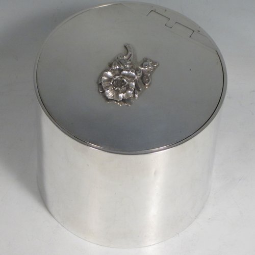 Sterling silver tea caddy box in a Georgian style, having a plain cylindrical body with straight sides, an invisibly hinged flat lid with floral finial, and sitting on a flat base. Made by Alston & Halom of London in 1918. The dimensions of this fine hand-made silver tea caddy box are height 10 cms (4 inches), diameter 11 cms (4.25 inches), and it weighs approx. 437g (14 troy ounces).