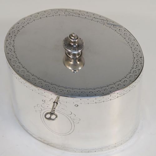 A very handsome Antique Georgian Sterling Silver tea caddy box, having an oval straight-sided body with an upper and lower band of hand-engraved floral decoration, a cast urn-shaped finial attached to a lid with flat hidden hinge and matching decoration, with original lock and key. This elegant antique silver tea caddy box was made by Joseph Preedy of London in 1778. The dimensions of this fine hand-made antique tea caddy box are height 11 cms (4.25 inches), length 12 cms (4.75 inches), width 9 cms (3.5 inches), and it weighs approx. 350g (11.3 troy ounces).