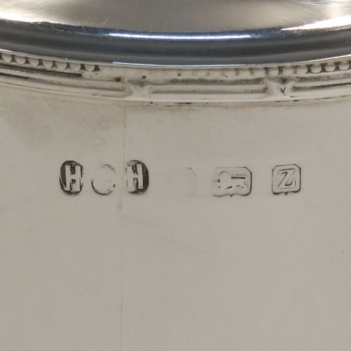 A very handsome Antique Sterling Silver tea caddy box, having a plain cylindrical body with straight sides and applied bead, ribbon and reed top and bottom borders, a slightly domed lift-off lid with a ball finial, and sitting on a flat base. This elegant silver tea caddy box was made by Hukin and Heath of Birmingham in 1924. The dimensions of this fine hand-made antique silver tea caddy box are height 13 cms ( 5inches), diameter 9 cms (3.5 inches), and it weighs approx. 255g (8.2 troy ounces).