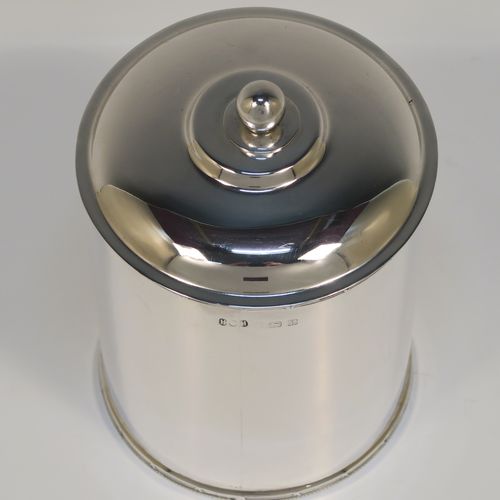 A very handsome Antique Sterling Silver tea caddy box, having a plain cylindrical body with straight sides and applied bead, ribbon and reed top and bottom borders, a slightly domed lift-off lid with a ball finial, and sitting on a flat base. This elegant silver tea caddy box was made by Hukin and Heath of Birmingham in 1924. The dimensions of this fine hand-made antique silver tea caddy box are height 13 cms ( 5inches), diameter 9 cms (3.5 inches), and it weighs approx. 255g (8.2 troy ounces).