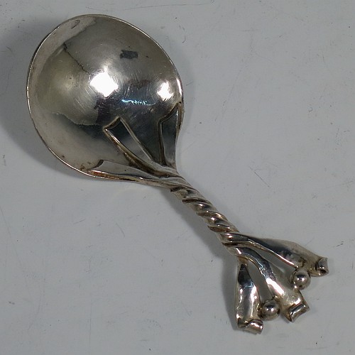 An Arts and Crafts Sterling Silver tea caddy spoon, having a cast twisted ribbon style handle with two applied beads between the turned-over ribbon ends, and a plenished hand-hammered round bowl. Made by Leonard William Burt of London in 1957. The dimensions of this fine hand-made Arts and Crafts style silver tea caddy spoon are length 9 cms (3.5 inches), width across bowl 4 cms (1.5 inches), and it weighs approx. 24g (0.75 troy ounces).
