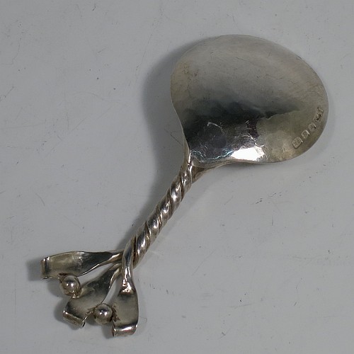 An Arts and Crafts Sterling Silver tea caddy spoon, having a cast twisted ribbon style handle with two applied beads between the turned-over ribbon ends, and a plenished hand-hammered round bowl. Made by Leonard William Burt of London in 1957. The dimensions of this fine hand-made Arts and Crafts style silver tea caddy spoon are length 9 cms (3.5 inches), width across bowl 4 cms (1.5 inches), and it weighs approx. 24g (0.75 troy ounces).