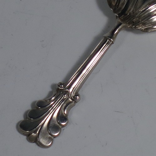 An Antique Georgian Sterling Silver tea caddy spoon, having a hand-chased handle with reeded anthemion leaf floral decoration, and a hand-chased fluted oval pointed bowl. Made by Thomas Fowke of London in 1831. The dimensions of this fine hand-made antique silver tea caddy spoon are length 10 cms (4 inches), width across bowl 3.5 cms (1.3 inches), and it weighs approx. 8g (0.25 troy ounces).
