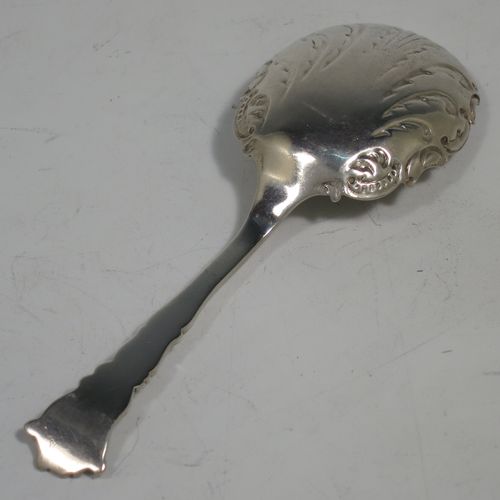 An Antique Sterling Silver tea caddy spoon, with a floral patterned handle, and a hand-chased oval bowl with scroll decoration. Made by Joseph Gloster of Birmingham in 1911. The dimensions of this fine hand-made antique silver tea caddy spoon are length 10 cms (4 inches), width across bowl 3.5 cms (1.3 inches), and it weighs approx. 18g (0.6 troy ounces).