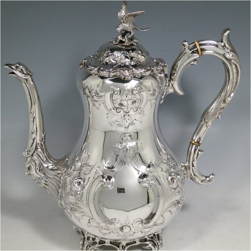An Antique Victorian Sterling Silver four-piece tea and coffee set, having round baluster bodies with hand-chased floral decoration, with silver insulated handles, cast eagle finials, eagle face spouts, the sugar bowl and cream jug with gold-gilt interiors, and all sitting on cast and hand-pierced feet. All made by Martin & Hall, with the teapot & cream jug from London in 1870, the coffee pot from Sheffield in 1890, and the sugar bowl from Sheffield in 1896. The dimensions of this fine hand-made silver tea and coffee service are length of teapot 27 cms (10.6 inches), height of coffee pot 26 cms (10.25 inches), and the total weight is approx. 2,253g (73 troy ounces).