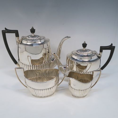 A very handsome Antique Victorian Sterling Silver Queen Anne style four-piece tea and coffee set consisting of a coffee pot, tea-pot, sugar bowl, and milk / cream jug, having oval bodies with hand-chased half-fluted decoration and applied reeded borders, with wooden handles and finials, and all sitting on collet feet. All made by James Dixon and Sons of Sheffield in 1894. The dimensions of this fine hand-made antique silver tea and coffee service are length of teapot 25.5 cms (10 inches), height of coffee pot 23.5 cms (9.25 inches), and the total weight is approx. 1,500g (48 troy ounces).  