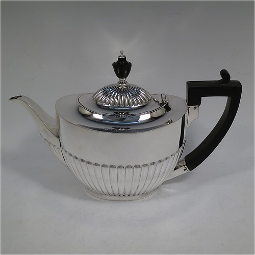 A very handsome Antique Edwardian Sterling Silver Queen Anne style four-piece tea and coffee set consisting of a coffee pot, tea-pot, sugar bowl, and milk / cream jug, having oval bodies with hand-chased half-fluted decoration, with wooden handles and finials, and all sitting on pedestal and collet feet. All made by Roberts and Belk of Sheffield in 1907/10. The dimensions of this fine hand-made antique silver tea and coffee service are length of teapot 26.5 cms (10.5 inches), height of coffee pot 26 cms (10.25 inches), and the total weight is approx. 1,350g (42 troy ounces).