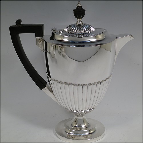 A very handsome Antique Edwardian Sterling Silver Queen Anne style four-piece tea and coffee set consisting of a coffee pot, tea-pot, sugar bowl, and milk / cream jug, having oval bodies with hand-chased half-fluted decoration, with wooden handles and finials, and all sitting on pedestal and collet feet. All made by Roberts and Belk of Sheffield in 1907/10. The dimensions of this fine hand-made antique silver tea and coffee service are length of teapot 26.5 cms (10.5 inches), height of coffee pot 26 cms (10.25 inches), and the total weight is approx. 1,350g (42 troy ounces).
