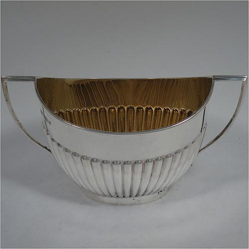 A very handsome Antique Edwardian Sterling Silver Queen Anne style four-piece tea and coffee set consisting of a coffee pot, tea-pot, sugar bowl, and milk / cream jug, having oval bodies with hand-chased half-fluted decoration, with wooden handles and finials, and all sitting on pedestal and collet feet. All made by Roberts and Belk of Sheffield in 1907/10. The dimensions of this fine hand-made antique silver tea and coffee service are length of teapot 26.5 cms (10.5 inches), height of coffee pot 26 cms (10.25 inches), and the total weight is approx. 1,350g (42 troy ounces).