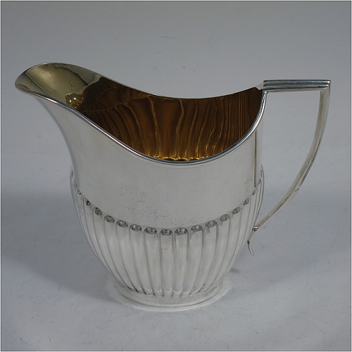 A very handsome Antique Edwardian Sterling Silver Queen Anne style four-piece tea and coffee set consisting of a coffee pot, tea-pot, sugar bowl, and milk / cream jug, having oval bodies with hand-chased half-fluted decoration, with wooden handles and finials, and all sitting on pedestal and collet feet. All made by Roberts and Belk of Sheffield in 1907/10. The dimensions of this fine hand-made antique silver tea and coffee service are length of teapot 26.5 cms (10.5 inches), height of coffee pot 26 cms (10.25 inches), and the total weight is approx. 1,350g (42 troy ounces).