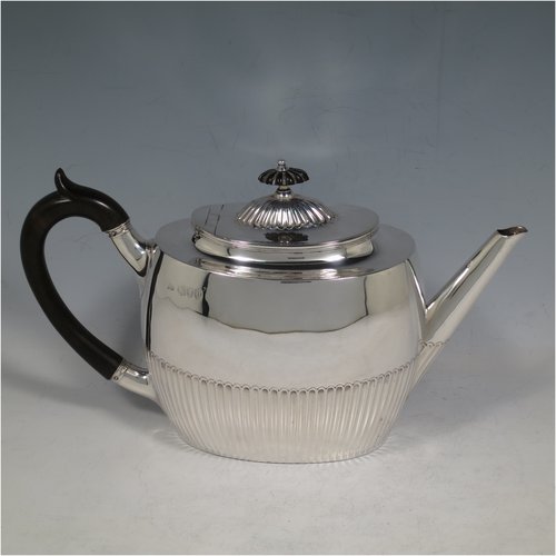 An Antique Victorian Sterling Silver Queen Anne style four-piece tea and coffee set consisting of a coffee pot, tea-pot, sugar bowl, and milk / cream jug, having oval bodies with hand-chased half-fluted decoration, with wooden handles and finials, and all sitting on flat bases. All made by Edward Hutton of London in 1890. The dimensions of this fine hand-made antique silver tea and coffee service are length of teapot 26 cms (10.25 inches), height of coffee pot 21 cms (8.25 inches), and the total weight is approx. 1,116g (36 troy ounces).    
