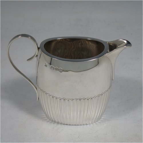 An Antique Victorian Sterling Silver Queen Anne style four-piece tea and coffee set consisting of a coffee pot, tea-pot, sugar bowl, and milk / cream jug, having oval bodies with hand-chased half-fluted decoration, with wooden handles and finials, and all sitting on flat bases. All made by Edward Hutton of London in 1890. The dimensions of this fine hand-made antique silver tea and coffee service are length of teapot 26 cms (10.25 inches), height of coffee pot 21 cms (8.25 inches), and the total weight is approx. 1,116g (36 troy ounces).    