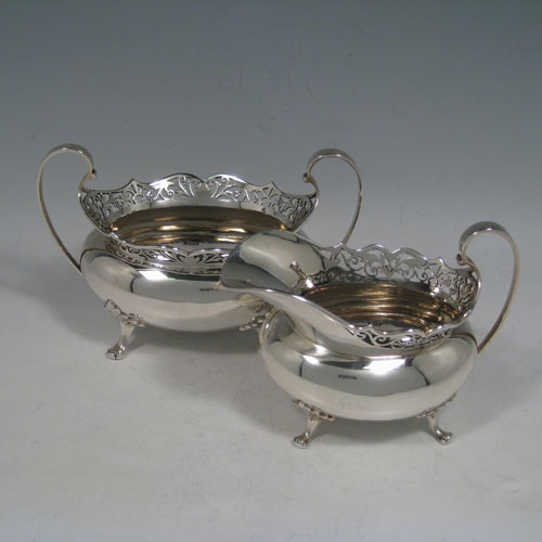 Antique Edwardian sterling silver tea and coffee service set, having plain oval baluster bodies, applied hand-pierced gallery top borders, black wooden handles and finials, and all sitting on four cast foliate feet. This set consists of a hot-water kettle on burner stand, a teapot, coffee pot, sugar bowl, and cream jug. All made by T.E. Co., Ltd., of Sheffield in 1904. The dimensions of this fine hand-made tea and coffee set are height (of kettle) 30.5 cms (12 inches), length (of teapot)30.5 cms (12 inches), and it weighs a total of approx. 2,850 (92 troy ounces). Please note that this service is crested.