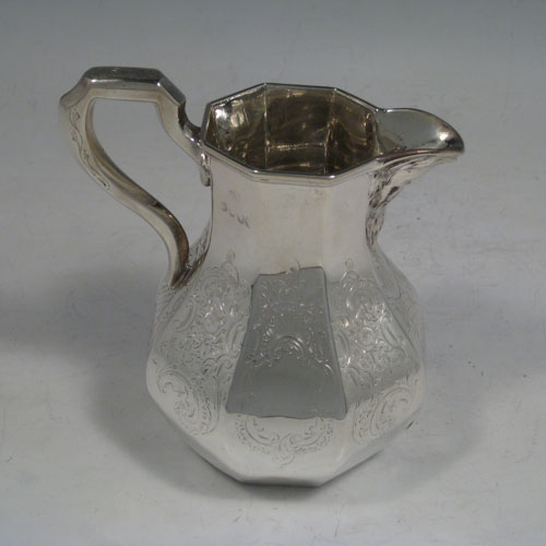 A very pretty Antique Victorian Sterling Silver four-piece tea and coffee service, consisting of a coffee pot, tea pot, sugar bowl, and cream jug, having octagonal panelled bodies with hand-engraved floral and scroll decoration, hinged lids with finials, and insulated silver handles. This beautiful antique silver tea and coffee set was made by William Kerr Reid of London in 1850. The dimensions of this fine hand-made silver service are height of coffee pot 25 cms (10 inches), length of teapot 23.5 cms (9.25 inches), and with a total weight approx. 1,740g (56 troy ounces).