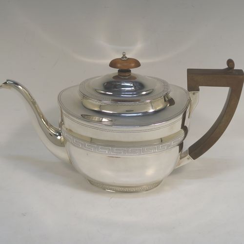 A very elegant Sterling Silver Georgian style four-piece tea and coffee service, consisting of a teapot, hot water or coffee pot, sugar bowl and cream jug. Having plain oval bodies with bands of hand-engraved Greek-Key decoration, the teapot and water pot with wooden handles and finials, the cream jug and sugar bowl with applied reeded borders, and all sitting on collet feet. This handsome silver tea and coffee service was made by James Dixon and Sons of Sheffield in 1939. The dimensions of this fine hand-made tea and coffee set are length of teapot 27.5 cms (10.75 inches), height of coffee pot 18.5 cms (7.25 inches), and the total weight is approx. 1,300g (42 troy ounces).