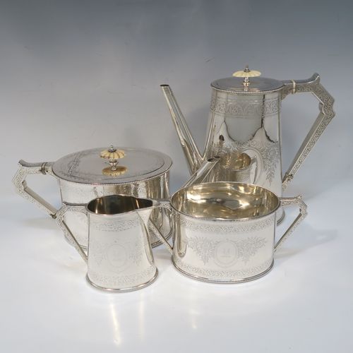A very pretty Antique Victorian Sterling Silver four-piece tea and coffee service, consisting of a coffee pot, tea pot, sugar bowl, and cream jug, in a Can or Lighthouse style having oval straight-sided bodies with hand-engraved floral and scroll decoration and applied bead-edged borders, flat hinged lids with bone finials, and insulated silver handles, all sitting on flat bases. This beautiful silver tea and coffee service was made by Elkington and Co., of Birmingham in 1887. The dimensions of this fine hand-made antique silver service set are height of coffee pot 23 cms (9 inches), length of teapot 28 cms (11 inches), and with a total weight of approx. 2,180g (70 troy ounces).  