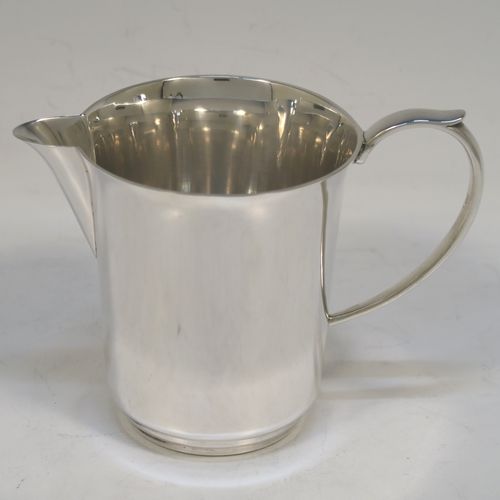 A very handsome and stylish Sterling Silver Art Deco style four-piece tea and coffee service, having very plain round bodies, with brown stained wooden handles and finials, and all sitting on flat stepped bases. This very elegant silver tea and coffee service was made by Alvic Products Ltd., of Birmingham in 1947. The dimensions of this fine hand-made Art Deco style tea and coffee set are length of teapot 23 cms (9 inches), height of coffee pot 15 cms (6 inches), and the total weight is approx. 1,127g (36 troy ounces).