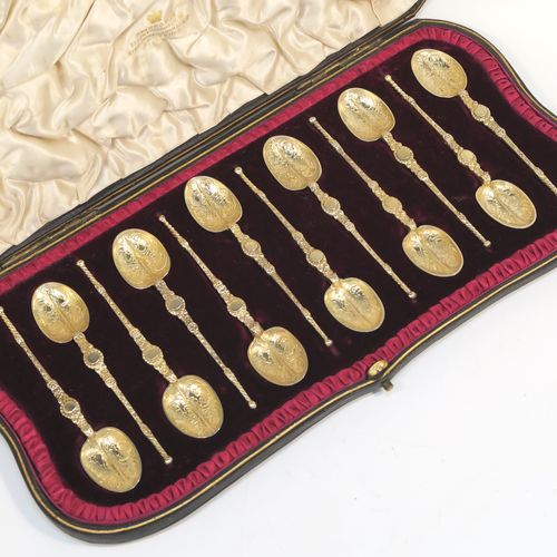A beautiful set of twelve Antique Victorian Sterling Silver and gold-gilt coffee spoons, in the Coronation Anointing pattern with hand-engraved floral decoration to the bowls, and cast ornate handles, all in their original cream satin and maroon velvet-lined presentation box. These pretty antique silver and gold-gilt coffee spoons were made by Wakely and Wheeler of London in 1901. The dimensions of this fine hand-made antique silver set of coffee spoons are length of each spoon 10.5 cms (4.25 inches), and the total weight is approx. 135g (4.4 troy ounce).