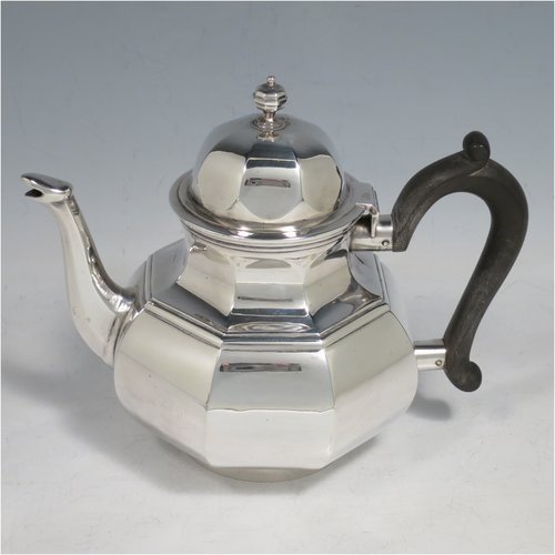 An Antique Victorian Sterling Silver three-piece bachelor tea set, having hexagonal panelled bodies, the teapot with a domed hinged lid with cast finial, a black wooden scroll handle, the cream and sugar bowl with gold gilt interiors and scroll handles, and all sitting on collet feet. Made by Joshua Vander of London in 1889. The dimensions of this fine hand-made antique silver tea set are height of teapot 14 cms (5.5 inches), length of teapot 17.5 cms (7 inches), with a total weight of approx. 589g (19 troy ounces).