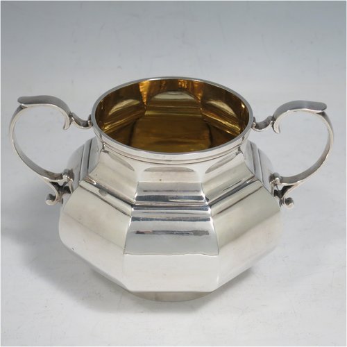 An Antique Victorian Sterling Silver three-piece bachelor tea set, having hexagonal panelled bodies, the teapot with a domed hinged lid with cast finial, a black wooden scroll handle, the cream and sugar bowl with gold gilt interiors and scroll handles, and all sitting on collet feet. Made by Joshua Vander of London in 1889. The dimensions of this fine hand-made antique silver tea set are height of teapot 14 cms (5.5 inches), length of teapot 17.5 cms (7 inches), with a total weight of approx. 589g (19 troy ounces).
