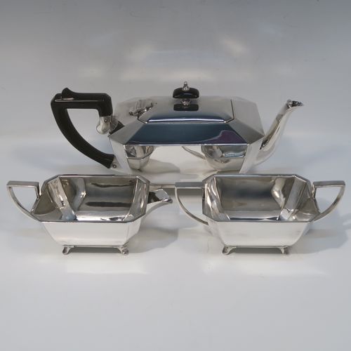 A very handsome and stylish Art Deco Silver-Plated  three-piece tea set, consisting of a teapot, sugar bowl, and cream jug, in a plain rectangular panelled style, with the teapot having a wooden handle with matching finial and a hinged lid, the cream jug and sugar bowl having angular handles and spout, and all sitting on four cast flanged feet. This elegant silver plated tea set was made by James Dixon and Sons of Sheffield in ca. 1930. The dimensions of this fine hand-made Art Deco silver-plated three-pieced tea set are height of teapot 13 cms (5 inches), length 28 cms (11 inches), and width 12 cms (4.75 inches).   