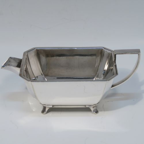 A very handsome and stylish Art Deco Silver-Plated three-piece tea set, consisting of a teapot, sugar bowl, and cream jug, in a plain rectangular panelled style, with the teapot having a wooden handle with matching finial and a hinged lid, the cream jug and sugar bowl having angular handles and spout, and all sitting on four cast flanged feet. This elegant silver plated tea set was made by James Dixon and Sons of Sheffield in ca. 1930. The dimensions of this fine hand-made Art Deco silver-plated three-pieced tea set are height of teapot 13 cms (5 inches), length 28 cms (11 inches), and width 12 cms (4.75 inches).