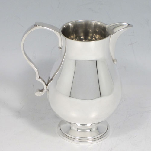 Sterling silver three-piece tea set, ccnsisting of teapot, sugar bowl, and cream jug, in a George I style having plain round baluster bodies, a hinged and domed lid, wooden insulated handle, a sparrow-beak style cream jug, and all sitting on pedestal feet. Made by Wakely and Wheeler of London in 1972. The dimensions of this fine hand-made silver tea set are height of teapot 16.5 cms (6.5 inches), length 21 cms (8.25 inches), and it weighs a total of approx. 830g (26.7 troy ounces).