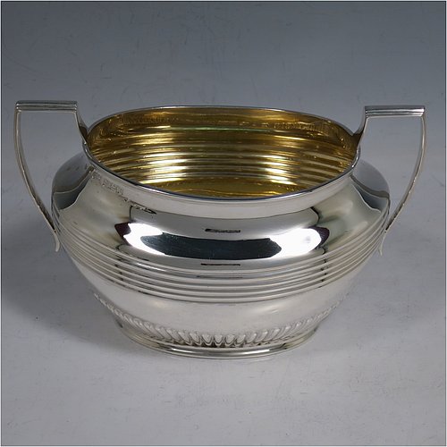 An elegant Antique Victorian Sterling Silver three-piece tea set, having oval shaped bodies, with fine half-fluted and reeded hand-chased decoration, reeded handles on the sugar & cream jug together with gold-gilt interiors, and a wooden handle & finial on the teapot, and all sitting on collet foot bases. This handsome silver tea service was made by Henry Stratford of Sheffield in 1900. The dimensions of this fine hand-made antique silver tea set are length of teapot 28 cms (11 inches), height 15 cms (6 inches), and the total weight is approx. 775g (25 troy ounces).