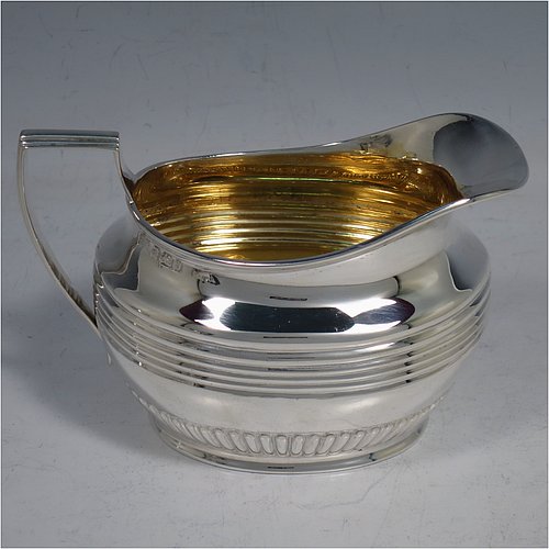 An elegant Antique Victorian Sterling Silver three-piece tea set, having oval shaped bodies, with fine half-fluted and reeded hand-chased decoration, reeded handles on the sugar & cream jug together with gold-gilt interiors, and a wooden handle & finial on the teapot, and all sitting on collet foot bases. This handsome silver tea service was made by Henry Stratford of Sheffield in 1900. The dimensions of this fine hand-made antique silver tea set are length of teapot 28 cms (11 inches), height 15 cms (6 inches), and the total weight is approx. 775g (25 troy ounces).
