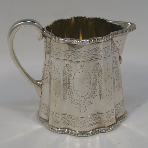 A heavy and very pretty Antique Victorian Sterling Silver three-piece tea set, consisting of a teapot, sugar bowl, and cream jug, having shaped oval bodies with straight sides, applied bead-edged borders, and hand-engraved Neoclassical style decoration, the teapot with a black wooden handle, finial, and a hinged lid with a flat invisible hinge, the sugar and creamer with scroll handles, gold-gilt interiors, and all sitting on flat bases. This beautiful silver three-piece tea set was made by Joseph Angell II and Robert Harper of London in 1872. The dimensions of this fine hand-made silver tea set are height of teapot 13.5 cms (5.3 inches), length 29 cms (11.5 inches), and it weighs a total of approx. 1,240g (44 troy ounces).