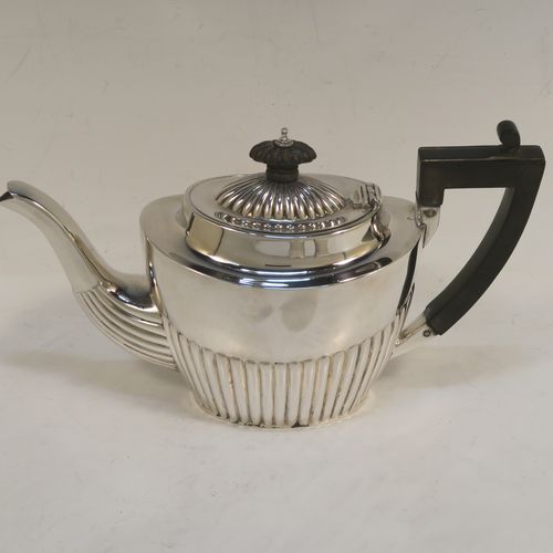 A handsome Antique Sterling Silver Bachelor three-piece tea set, having oval shaped bodies, with half-fluted hand-chased decoration, with reeded handles on the sugar & cream jug, a wooden handle and finial on the teapot, and all sitting on flat bases. This beautiful antique silver bachelor tea set was all made by John Milward Banks of Birmingham in 1896. The dimensions of this fine hand-made antique silver bachelor tea set are length of teapot 21.5 cms (8.5 inches), height 12.5 cms (5 inches), and the total weight is approx. 320g (10.3 troy ounces).