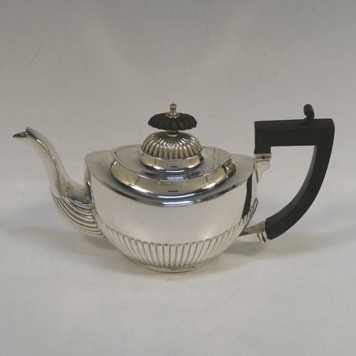 A pretty Antique Sterling Silver Bachelor three-piece tea set, having oval shaped bodies, with half-fluted hand-chased decoration, gold-gilt interiors and reeded handles on the sugar & cream jug, a wooden handle and finial on the teapot, and all sitting on flat bases. This beautiful antique silver bachelor tea set was all made by Albert Bloxham of London and Birmingham in 1908 and 1913. The dimensions of this fine hand-made antique silver bachelor tea set are length of teapot 21.5 cms (8.5 inches), height 12 cms (4.75 inches), and the total weight is approx. 300g (9.7 troy ounces).