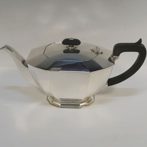 A very handsome Sterling Silver Art Deco style three-piece tea set, consisting of a teapot, sugar bowl, and cream jug, having plain panelled bodies and angular handles, the teapot with a black wooden handle, finial, and a hinged lid, and all sitting on collet feet. This elegant silver tea set was made by the Cooper Brothers of Sheffield in 1966. The dimensions of this fine hand-made Art Deco style silver tea set are height of teapot 13.5 cms (5.3 inches), length 28 cms (11 inches), and it weighs a total of approx. 1,062g (34 troy ounces).