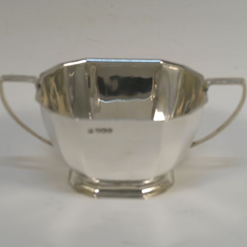 A very handsome Sterling Silver Art Deco style three-piece tea set, consisting of a teapot, sugar bowl, and cream jug, having plain panelled bodies and angular handles, the teapot with a black wooden handle, finial, and a hinged lid, and all sitting on collet feet. This elegant silver tea set was made by the Cooper Brothers of Sheffield in 1966. The dimensions of this fine hand-made Art Deco style silver tea set are height of teapot 13.5 cms (5.3 inches), length 28 cms (11 inches), and it weighs a total of approx. 1,062g (34 troy ounces).