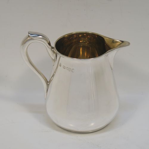 A very handsome Antique Victorian Sterling Silver three-piece tea set, consisting of a teapot, sugar bowl and cream jug. The bodies in a plain round bellied style with scroll handles, the teapot with a flat topped hinged lid and a silver handle and finial, the sugar bowl and cream jug with gold-gilt interiors, and all sitting on flat bases. This elegant silver tea set was made by Hunt and Roskell of London in 1878. The dimensions of this fine hand-made antique silver tea service are length of teapot 20 cms (8 inches), height 12.5 cms (5 inches), and it weighs a total of approx. 950g (31 troy ounces).  