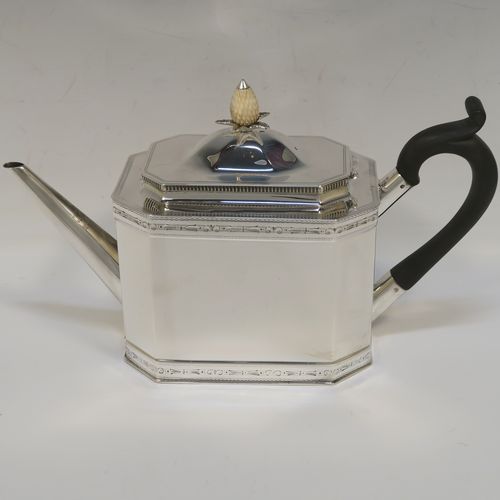 A heavy Sterling Silver three-piece tea set, in a neoclassical style, having plain octagonal bodies with straight sides, applied bead-edged borders above and below bands of bright-cut engraving, with flat-topped scroll side-handles, the teapot with a black wooden scroll handle and a domed lid with bone pineapple finial, and all sitting on flat bases. This beautiful silver three-piece tea set was made by Mappin and Webb of Sheffield in 1926. The dimensions of this fine hand-made silver tea set are length of teapot 26 cms (10.75 inches), height 13.5 cms (5.3 inches), and the total weight is approx. 1,100g (35.5 troy ounces).